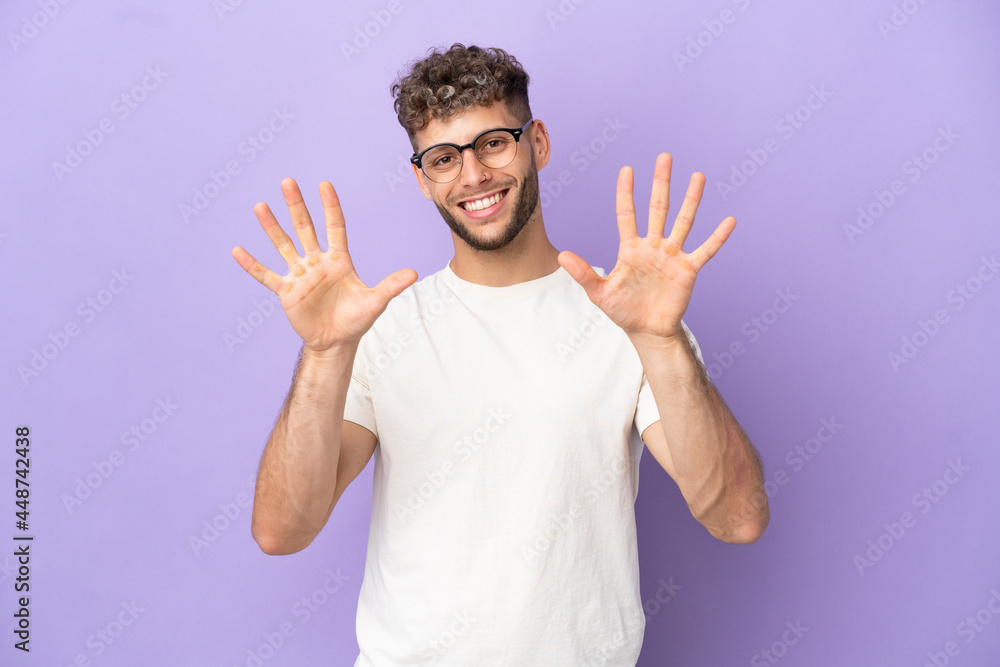 Naklejka premium Delivery caucasian man isolated on purple background counting ten with fingers