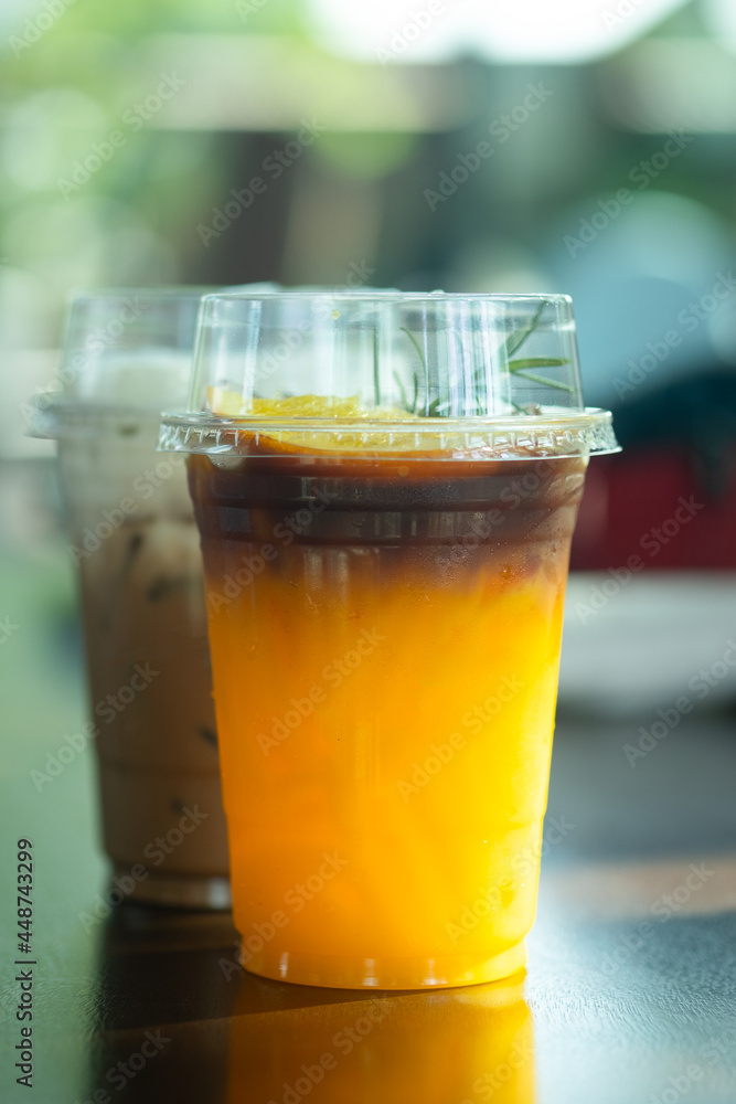 A glass of iced black coffee mix with orange juice