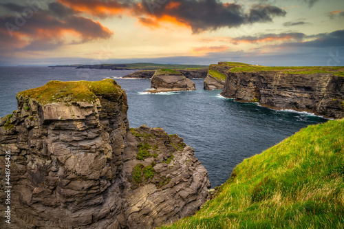Photo Rocky cliffs in Kilkee at sunset, County Clare. Ireland.