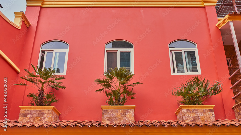 Fachada de hotel color salmón con ventanas simétricas y balcones Stock  Photo | Adobe Stock