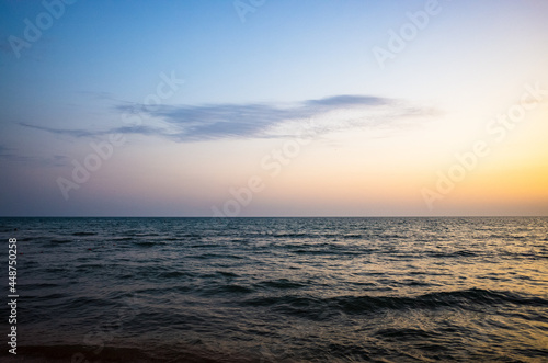 Evening sea landscape. Calm water. There is one small cloud in the sky. Copy space.