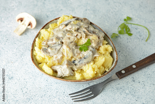 Bowl with tasty mashed potatoes and mushrooms on table