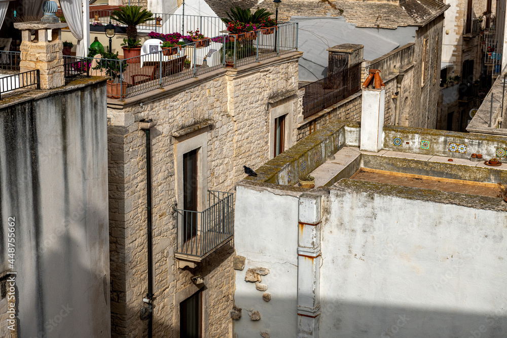 widok na kamienne budynki i tarasy na dachach w jednym z miasteczek na południu Włoch - obrazy, fototapety, plakaty 