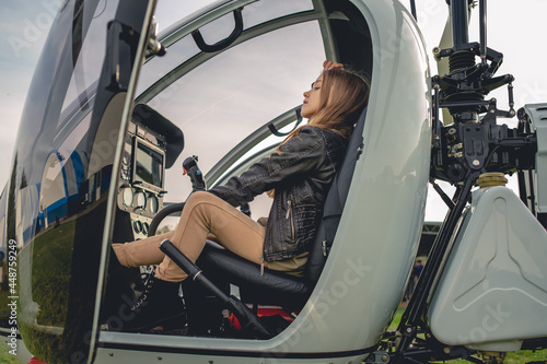 Dreamy preteen girl sitting on pilot seat in helicopter cockpit