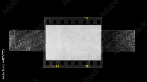 empty or blank 35mm dia film frame fixed by transparent sticker adhesive tape on black background. poster or design element.