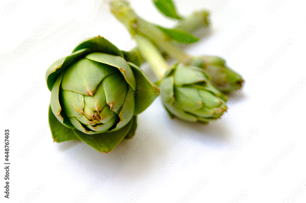Obraz premium three green artichoke isolated on white background with empty space