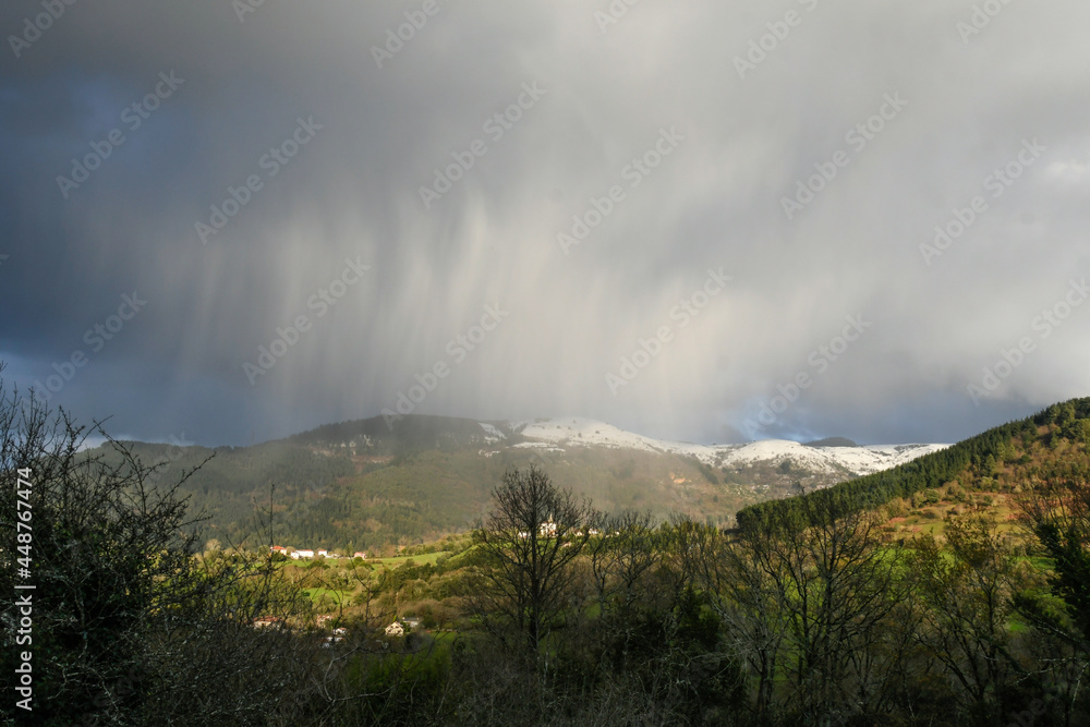 Waterspout over the snowy mountains in Galdames