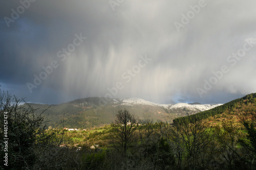 Waterspout over the snowy mountains in Galdames