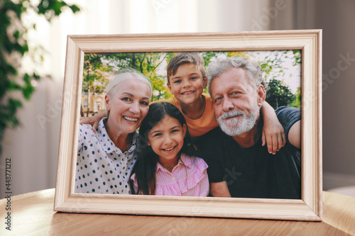 Framed family photo on wooden table in room