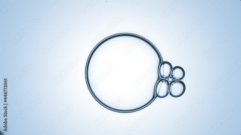 Big clear bubble of glycerine attracts four connected small ones on blue background | Shot of skincare cream ingredients for skin hydration concept Big clear bubble of glycerine attracts four connected small ones on blue background | Shot of skincare cream ingredients for skin hydration concept