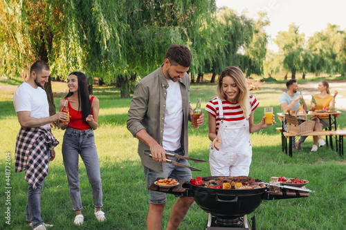 Canvas Print Group of friends having barbecue party in park