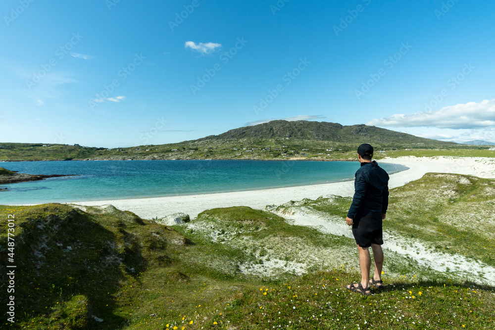 A young traveler admiring the scenery of the paradise beach of Dog's Bay Galway, Ireland