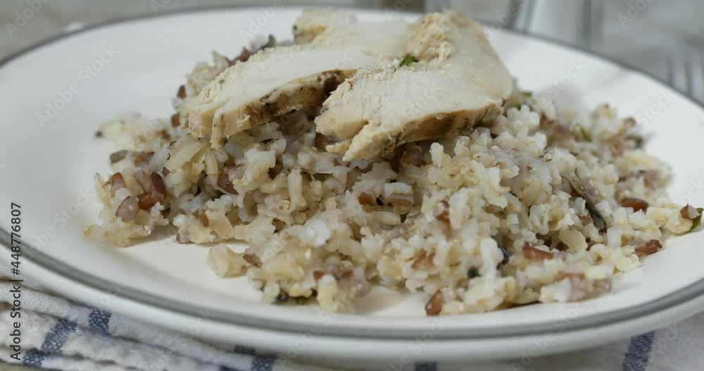 Placing slices of roasted chicken breast on a bed of rice slow motion Placing slices of roasted chicken breast on a bed of rice slow motion
