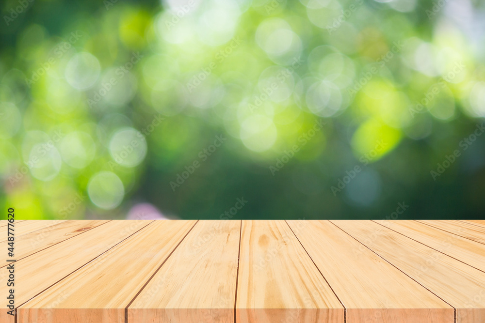 Wood floor with blurred trees of nature park background and summer season, product display montage Wood floor with blurred trees of nature park background and summer season, product display montage