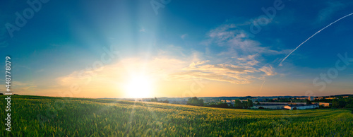 Vászonkép Sunset panorama on green summer field with beautiful sky