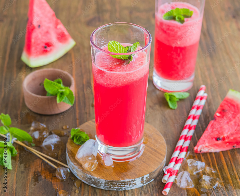 Refreshing soft drink, watermelon lemonade or Aqua fresca in glasses on a brown wooden background. Drink recipes. Refreshing soft drink, watermelon lemonade or Aqua fresca in glasses on a brown wooden background. Drink recipes.