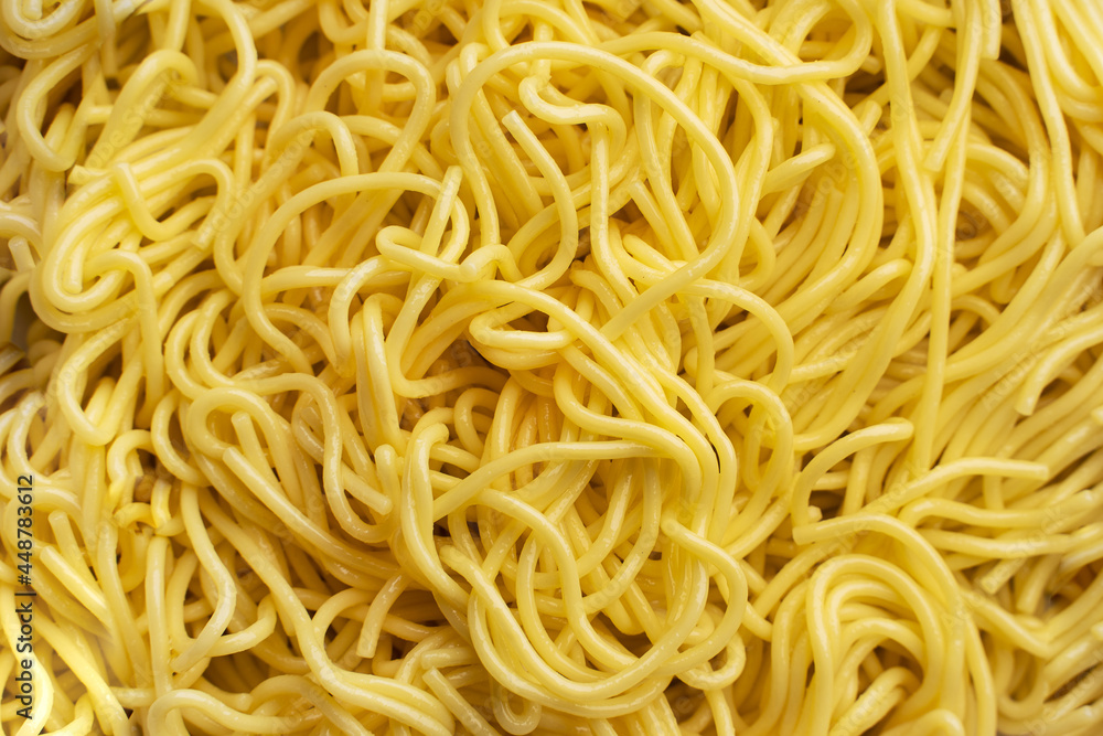 The texture of egg noodles. Yellow noodles are visible throughout the frame. An ingredient for making a wok. Asian food. Asian pasta. Cooking food. Strid food. Gluten-free fries. The texture of egg noodles. Yellow noodles are visible throughout the frame. An ingredient for making a wok. Asian food. Asian pasta. Cooking food. Strid food. Gluten-free fries.