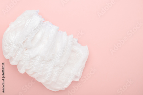 Diapers are disposable panties on a pink background with a place to copy. top view, copy space.