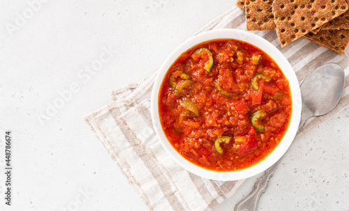 Matbucha - Moroccan Tomato dip. Sauce of tomato, pepper, garlic and chili pepper in a bowl on a white background. Vegan food.