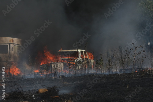 Burning car in a field covered by fire