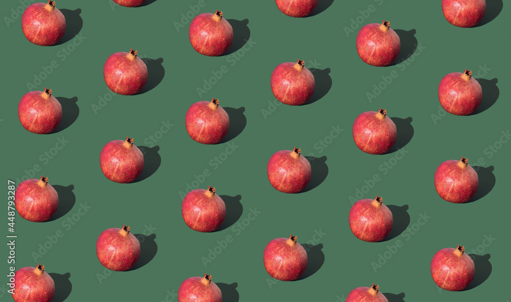 Pomegranate pattern on green background. Creative fruit minimal concept idea. Pomegranate pattern on green background. Creative fruit minimal concept idea.