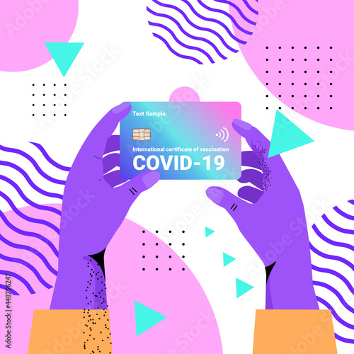 human hands holding plastic international certificate of vaccination global immunity passport risk free covid-19