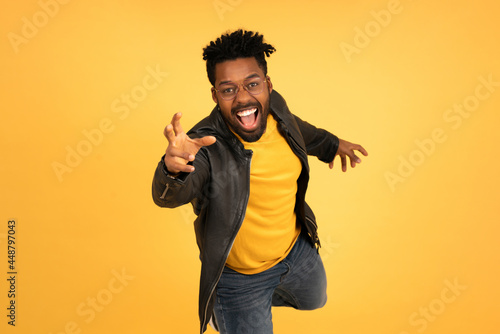 Young afro man trying to catch something with his hand.