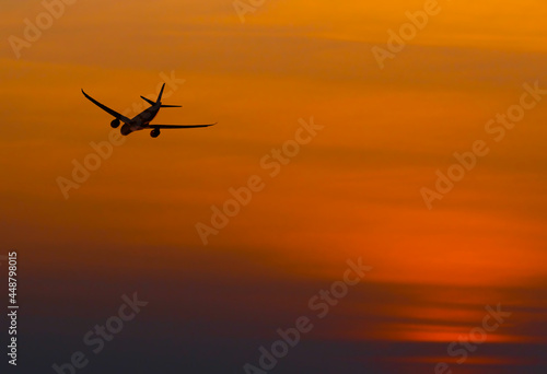 The silhouette selective focus view of airliner taking off against the sunset sky in the evening © pingaero
