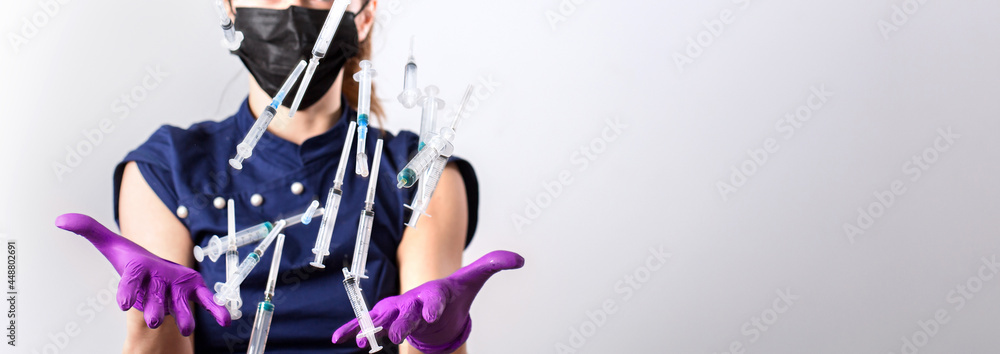 Woman throws up medical injections syringes in her outstretched hands towards the camera. Selective focus, copy space. Nurse: what to do with used syringes? Woman throws up medical injections syringes in her outstretched hands towards the camera. Selective focus, copy space. Nurse: what to do with used syringes?