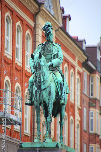 Equestrian statue or monument of King Christian IX in bronze   Aalborg  Denmark. Surrounded by historic buildings  close to the train station in the city center of Alborg.
