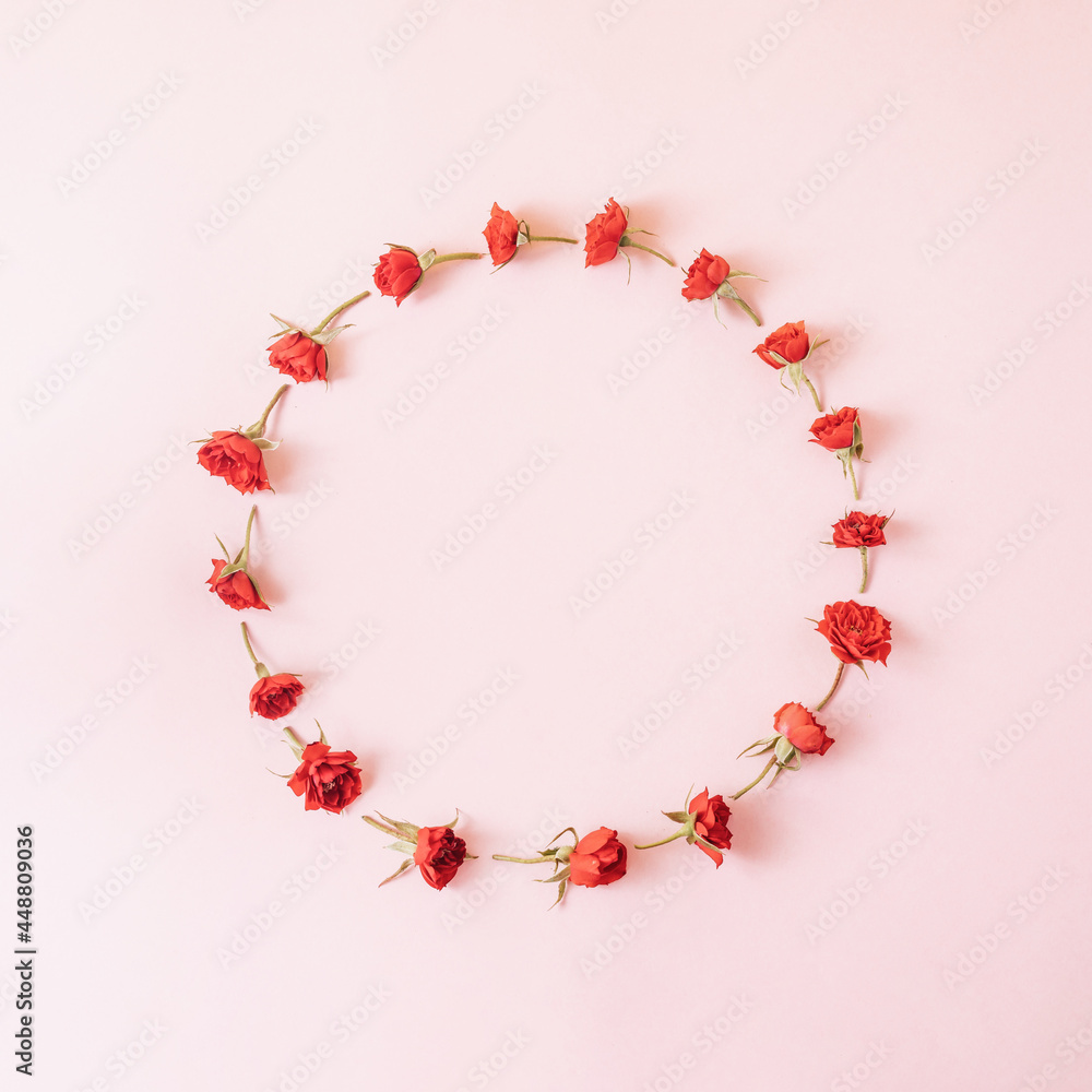 Creative layout made of red roses on pastel pink background. Minimal holiday concept. Flat lay pattern.
