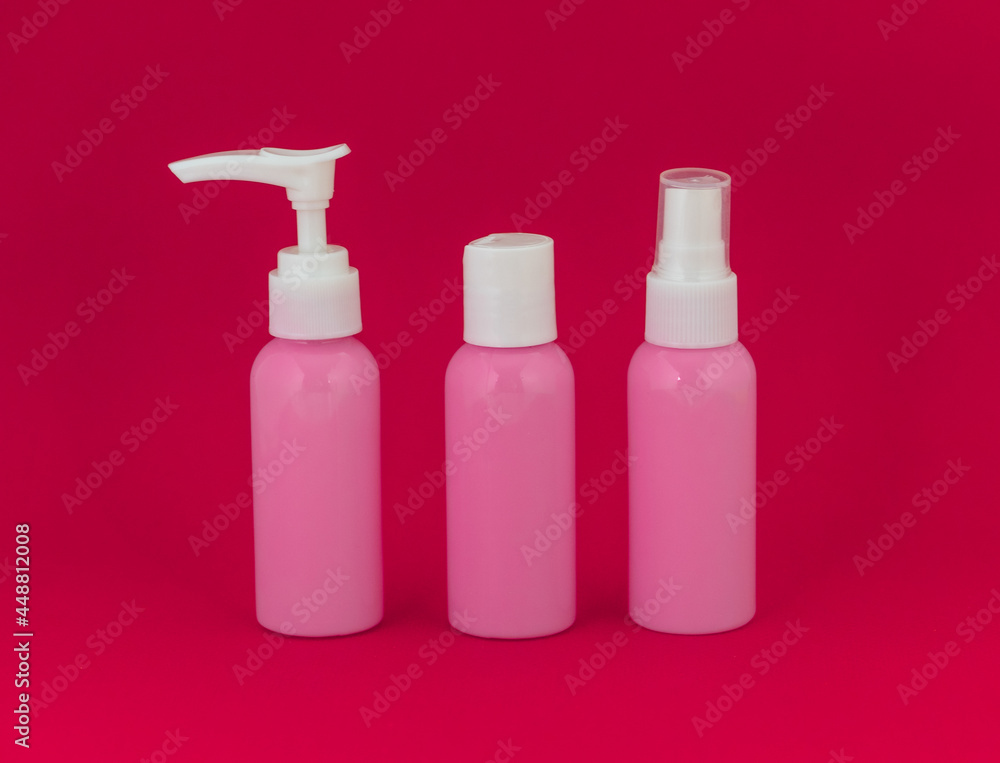 Three cosmetic bottles with white caps Three cosmetic bottles with white caps