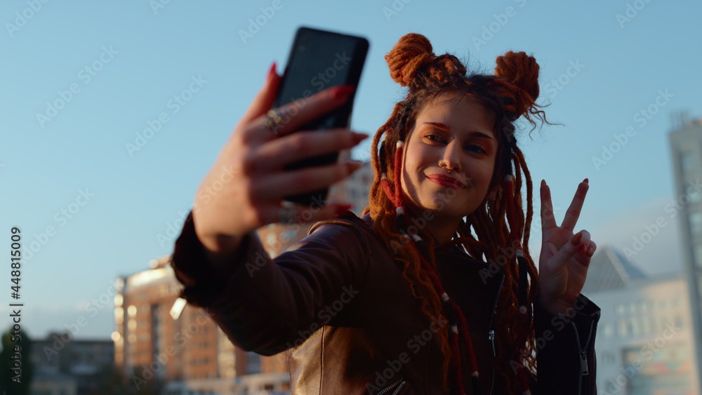 Cheerful woman making selfie on cellphone. Smiling girl posing to phone camera. Cheerful woman making selfie on cellphone. Smiling girl posing to phone camera.