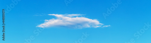 Small white cloud in the blue sky in the style of minimalism, panorama