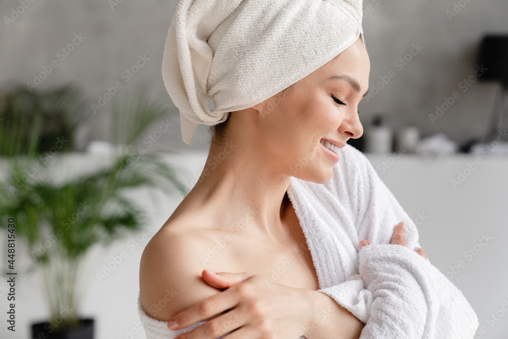 Calm serene young woman in spa bathrobe and towel relaxing after taking shower bath at home. Beauty treatment concept. Body skin and hair care - obrazy, fototapety, plakaty 