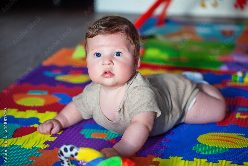 a small child crawls on a developing colored mat a small child crawls on a developing colored mat