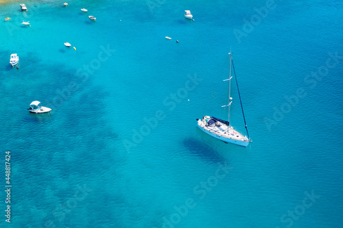 Aerial view of sailboat and small boats or yachts in the turquoise waters of the Adriatic sea