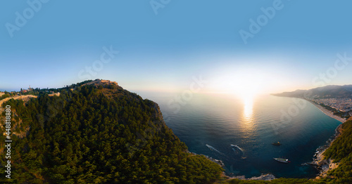 Fototapeta Naklejka Na Ścianę i Meble -  Large panorama. Wide aerial view from Kalesi Castle peninsula. Alanya, southern coast of Turkey, Summer sunset. Travel and vacation. Ships and boats in the mediterranean. Cleopatra beach and lake