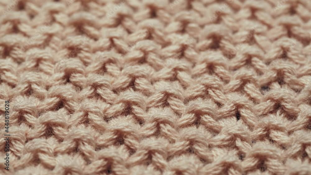 Knitted wool beige fabric close-up, features of washing clothes, texture background with garter stitch pattern. Knitted wool beige fabric close-up, features of washing clothes, texture background with garter stitch pattern.