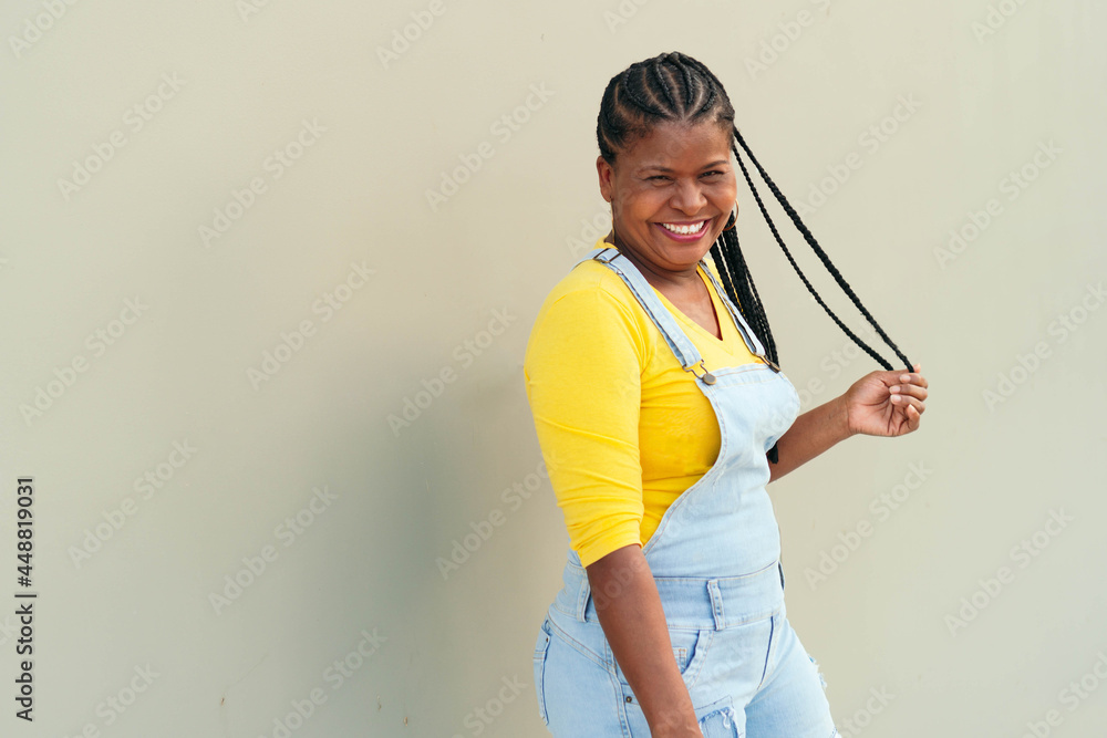 Mature black woman posing against the wall background Mature black woman posing against the wall background
