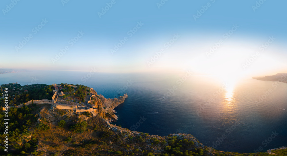 Large panorama. Wide aerial view from Kalesi Castle peninsula. Alanya, southern coast of Turkey, Summer sunset. Travel and vacation. Ships and boats in the sea. Cleopatra beach and lake. Copy space