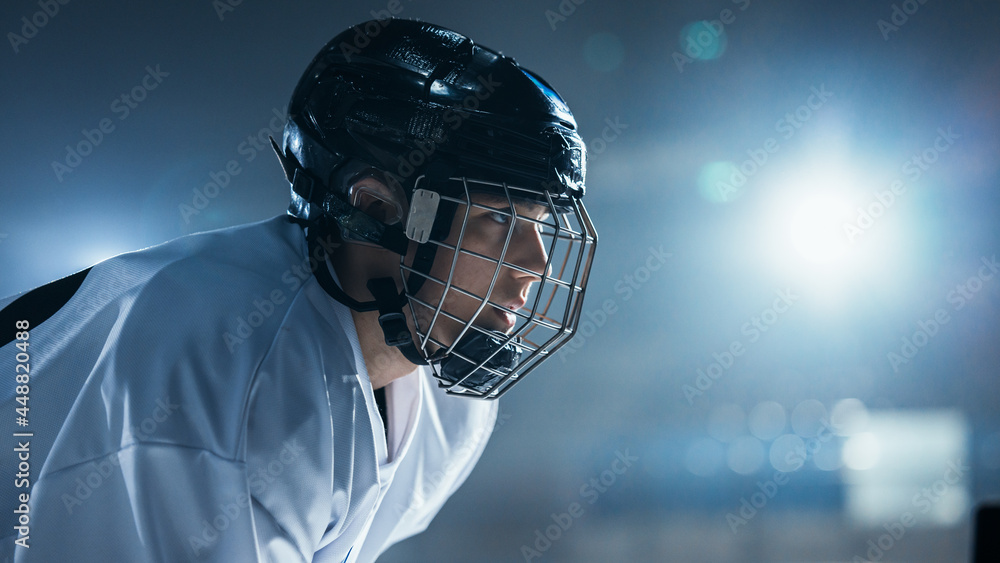 Ice Hockey Rink Arena: Portrait of Confident and Concentrated Professional Player, Wearing Wire Cage Face Mask, Looking afar. Focused Athlete, Determined to Win and be Champion.