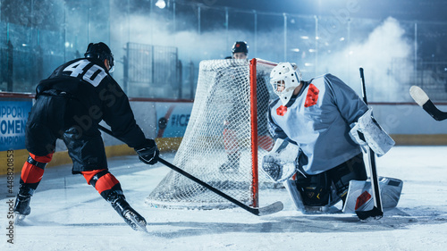 Photography Ice Hockey Rink Arena: Goalie Against Forward Player who is Doing Slapshot, Shots Puck with Stick and Trying to Score a Goal