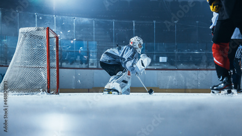 Ice Hockey Rink Arena: Goalie is Ready to Defend Score against Forward Player who Shoots Puck with Stick. Forwarder against Goaltender. Tension Moment in Sport Full of Emotions.