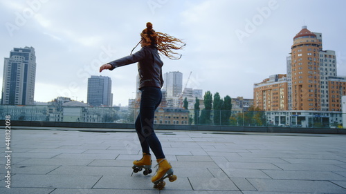 Valokuva Sporty ginger woman performing elements of rollerblading on urban background