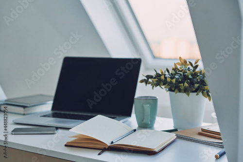 Image of laptop and note pad laying on the office desk