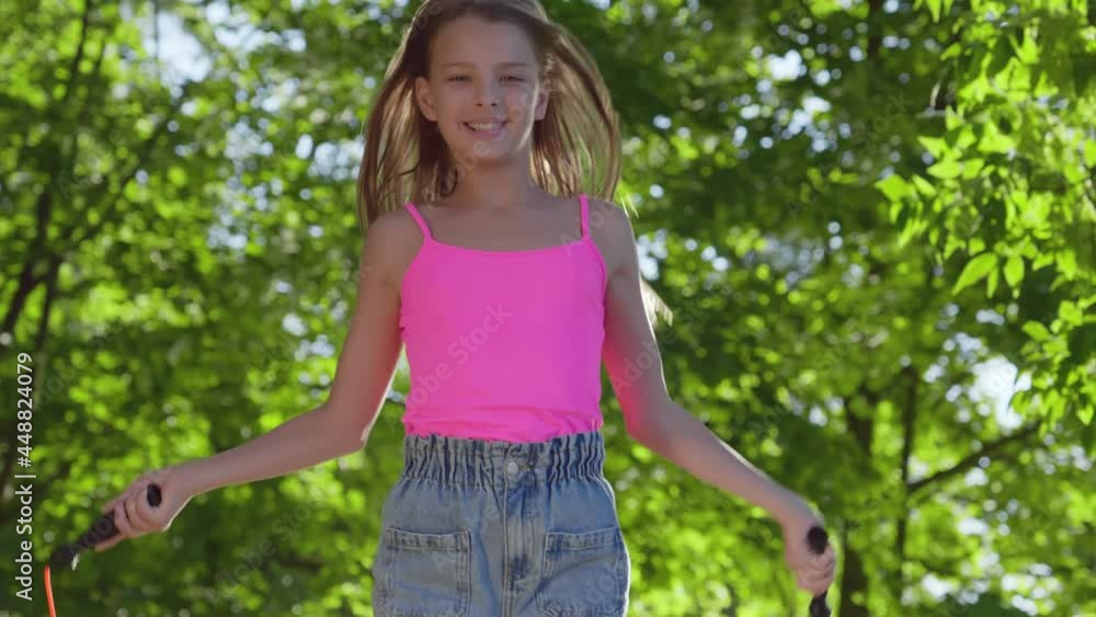 Cute preteen girl with jumping rope in park 