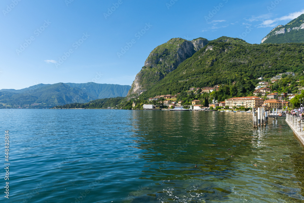 Beautiful view over the stunning lake Como in Lombardy, Italy. It is a very nice sunny summer day, with blue sky and a few white clouds. View is from the harbour in the city of Menaggio