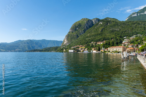 Beautiful view over the stunning lake Como in Lombardy, Italy. It is a very nice sunny summer day, with blue sky and a few white clouds. View is from the harbour in the city of Menaggio