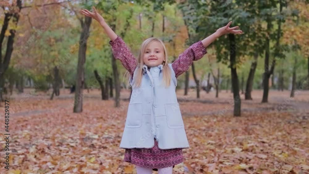 Little girl rejoices in autumn in the park and throws up leaves Little girl rejoices in autumn in the park and throws up leaves